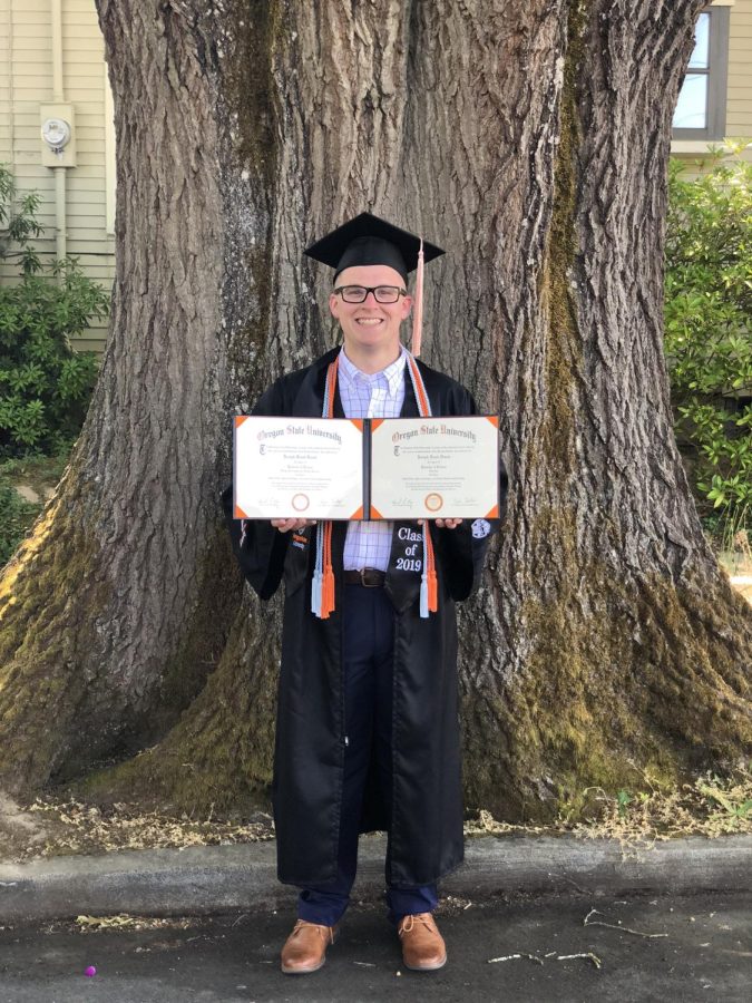 Joey holding his dual diplomas earned at Oregon State University.